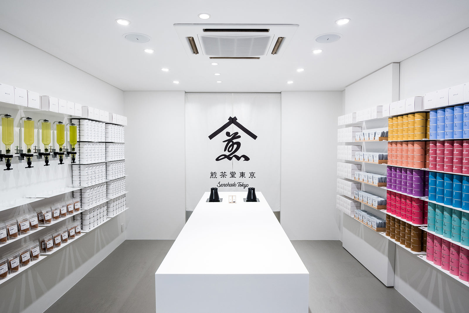 煎茶堂東京 銀座店の店内。正面の暖簾に煎茶堂東京のロゴ、両脇の棚に茶缶が並ぶ
